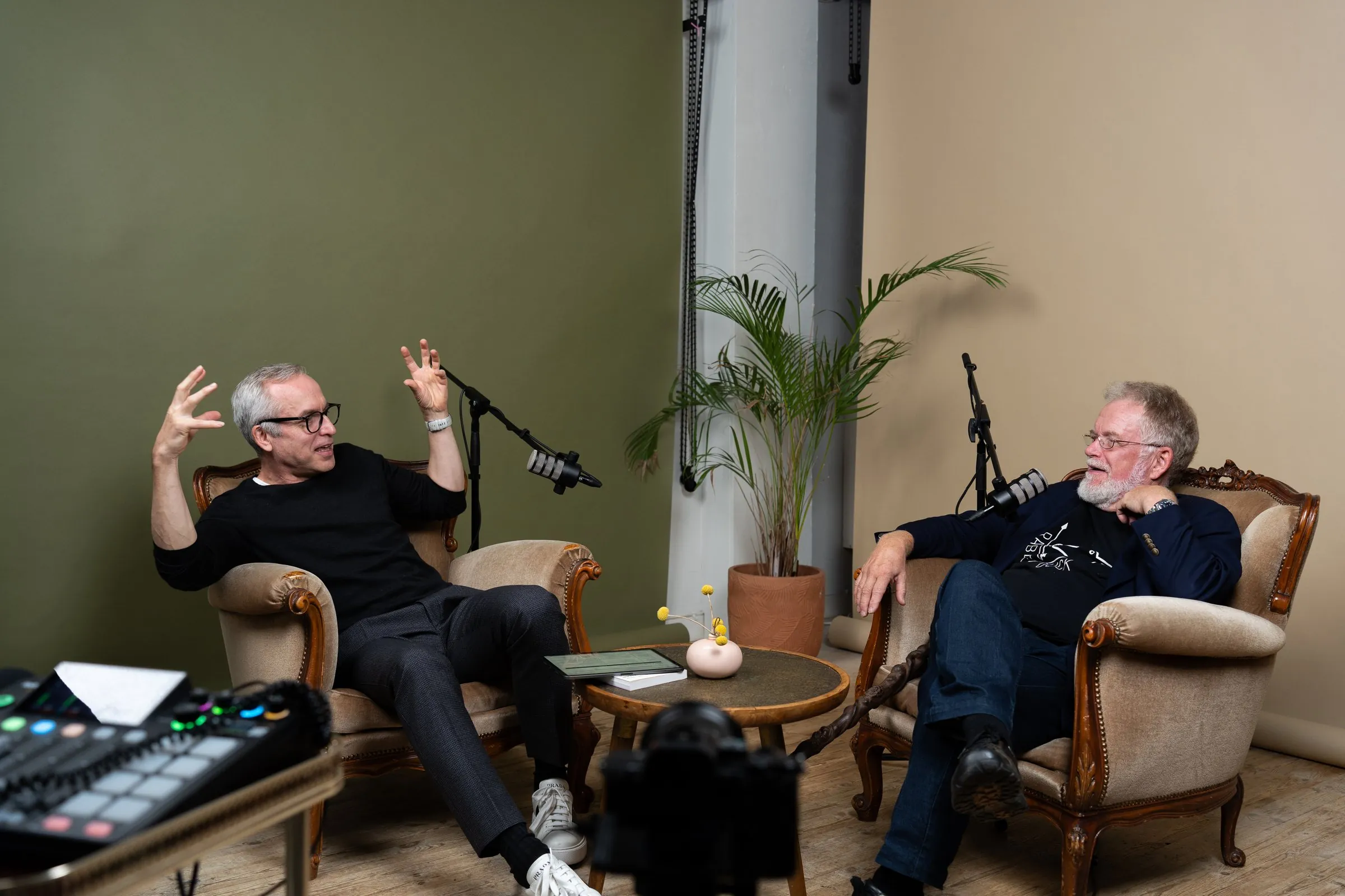 Olli-Pekka Pohjanmäki and Paul Lillrank talking in armchairs in front of microphones.